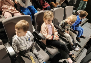 Na zdjęciu widzimy dzieci, które oczekują na przedstawienie.