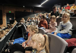 Na zdjęciu widzimy dzieci, które oglądają przedstawienie.
