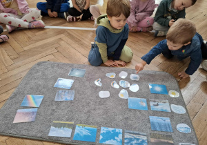 dzieci wskazują zdjęcia z symbolami pogody