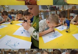 dzieci dmuchają przez słomkę na farbowaną wodę