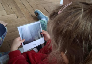 dziewczynka ogląda zdjęcia z mgłą w lesie