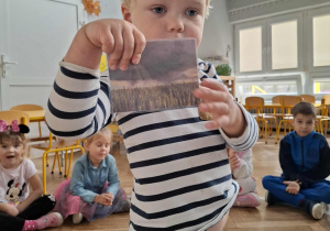 chłopiec pokazuje zdjęcie z pochmurną pogodą