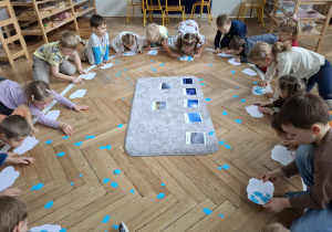 dzieci dmuchają na papierowe krople