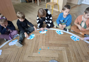 dzieci układają, liczą krople z paieru na chmurze z papieru