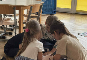 Zdjęcie przedstawia dzieci w kółeczku podczas wykonywania zadania.