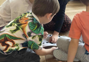 Zdjęcie przedstawia dzieci w kółeczku podczas wykonywania zadania.