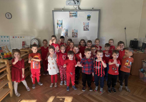 Zdjęcie przedstawia dzieci stojące w grupie i wyciągające rękę przed siebie w geście STOP.