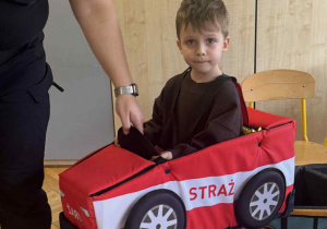 Zdjęcie przedstawia chłopca w autku z gąbki.