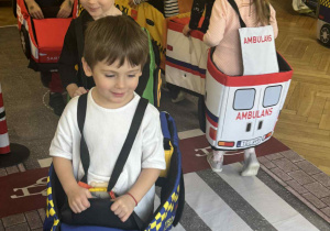 Zdjęcie przedstawia dzieci poruszające się po drodze autkami z gąbki.