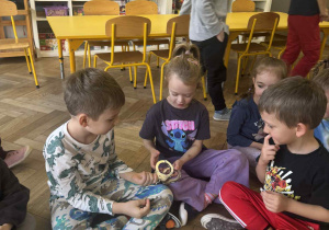 Zdjęcie przedstawia dzieci oglądające kajdanki.