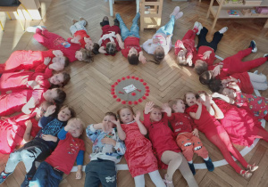 Czerwony dzień - dzieci ubrane w kolorze czerwonym leżą wkoło ułożonej mandali