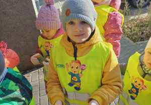 Chłopiec trzyma w ręku ulotki.