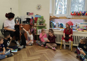 nauczyciel pokazuje zdjęcie , a dziewczynka opowiada kto na nim jest