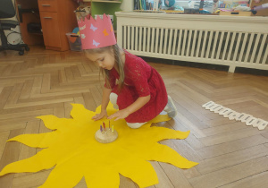 dziewczynka szykuje słoneczko do urodzin