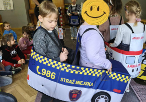 Na zdjęciu widzimy dzieci w autach, którzy "jadą" po drodze.