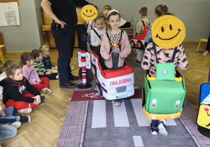 Na zdjęciu widzimy dzieci w autach, którzy "jadą" po drodze.