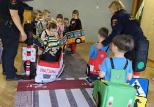 Na zdjęciu widzimy dzieci w autach, którzy "jadą" po drodze.