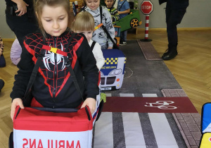 Na zdjęciu widzimy dzieci w autach, którzy "jadą" po drodze.