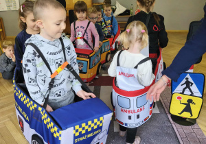 Na zdjęciu widzimy dzieci w autach, którzy "jadą" po drodze.