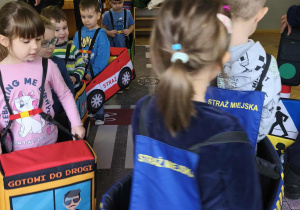 Na zdjęciu widzimy dzieci w autach, którzy "jadą" po drodze.