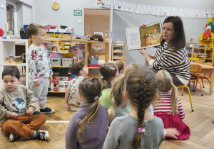 Na zdjęciu widzimy mamę Kubusia i dzieci, które słuchają opowiadania o krasnoludkach, które pisały list do Mikołaja.