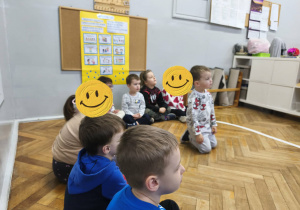 Na zdjęciu widzimy grupkę dzieci, które słuchają opowiadania "Ence-pence...".