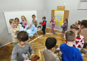 Na zdjęciu widzimy dzieci, które uczestniczą w zabawie "Podrzuć i złap misia".