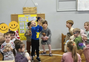 Na zdjęciu widzimy dzieci, które uczestniczą w zabawie "Podrzuć i złap misia".