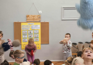 Na zdjęciu widzimy dzieci, które uczestniczą w zabawie "Podrzuć i złap misia".