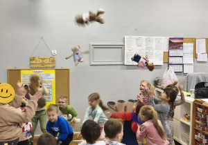 Na zdjęciu widzimy dzieci, które uczestniczą w zabawie "Podrzuć i złap misia".