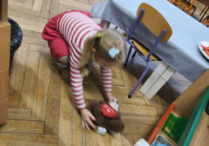 Na zdjęciu widzimy dziewczynkę, która odnalazła schowanego misia.