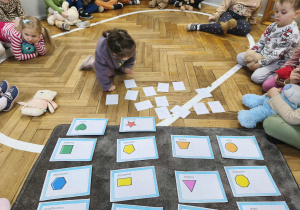 Na zdjęciu widzimy dziecko, które będzie odkrywało ilustrację misia i dopasowało go do odpowiedniego kształtu.