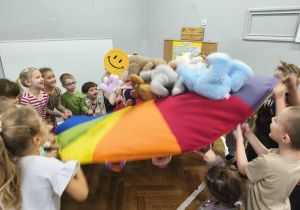 Na zdjęciu widzimy dzieci, które uczestniczą w zabawie z wykorzystaniem chusty animacyjnej.