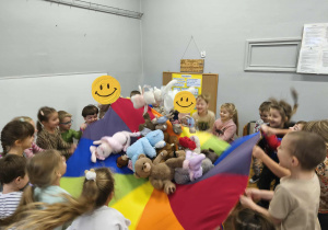 Na zdjęciu widzimy dzieci, które uczestniczą w zabawie z wykorzystaniem chusty animacyjnej.