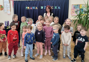 Dzieci stoją wokoło poetki.