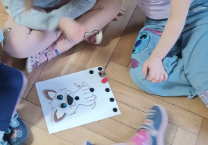 Dzieci siedzą nad kartą pracy.