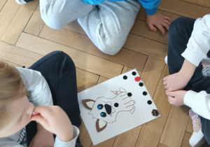 Dzieci siedzą nad kartą pracy.