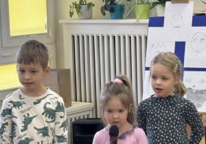 Zdjęcie przedstawia dziewczynkę mówiącą do mikrofonu.