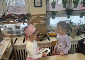 Zdjęcie przedstawia dziewczynkę składającą życzenia koleżance.