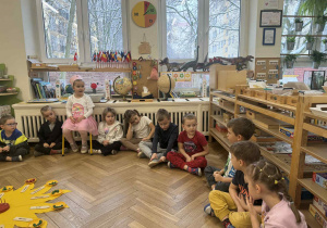 Zdjęcie przedstawia dzieci siedzące w kole podczas rozmowy.