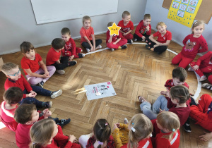 Dzieci siedzą w kole i rozmawiają o prawie do życia bez przemocy.