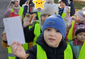 Dzieci rozdają ulotki dwóm paniom.