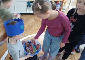 Dziewczynka częstuje się żelkami.