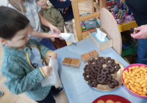 Chłopiec częstuje się słodyczami.