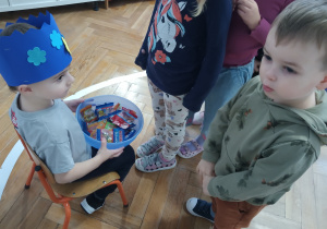 Chłopiec częstuje się żelkami.