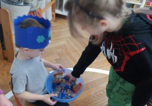 Chłopiec częstuje się żelkami.