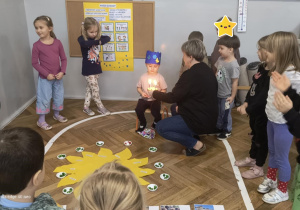 Chłopiec zdmuchuje świeczki na symbolicznym torcie.