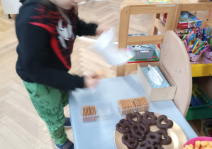 Chłopiec częstuje się słodyczami.