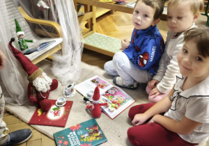 Dzieci obserwują efekt zabaw psotnych Elfów podczas czytania książek