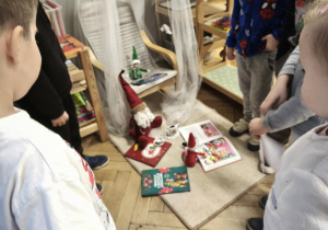 Dzieci obserwują efekt zabaw psotnych Elfów podczas czytania książek